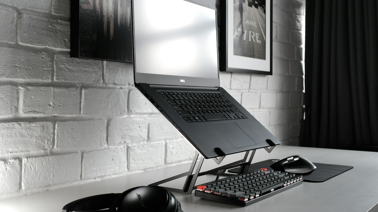 A laptop raised on a stand at a desk